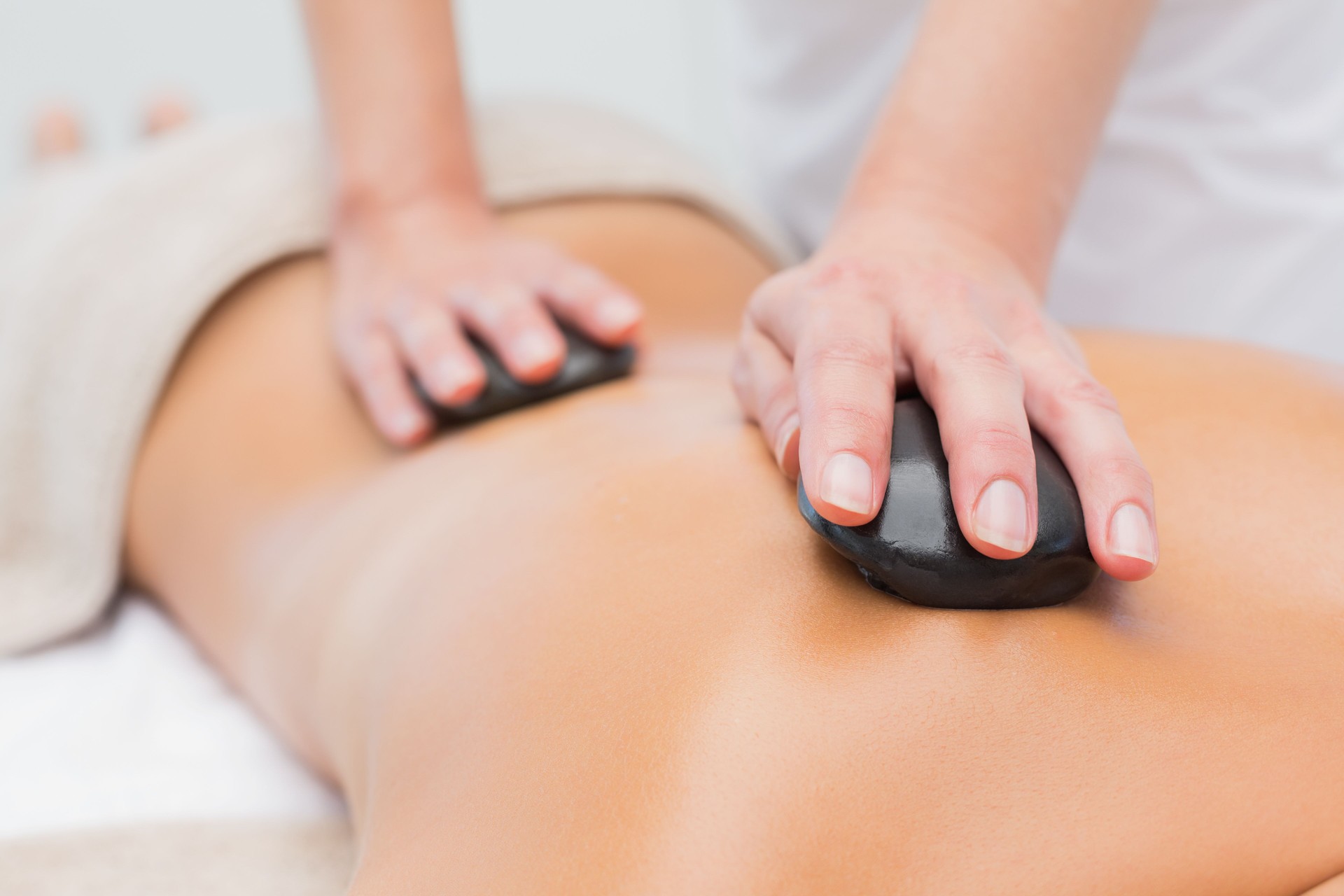 Beautiful woman receiving stone massage at spa center